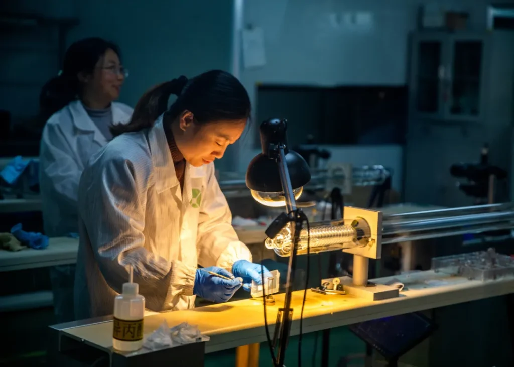 Precision CO2 Laser Tube Assembly and Inspection Technician carefully assembling and inspecting a CO2 laser tube during precision laser manufacturing.